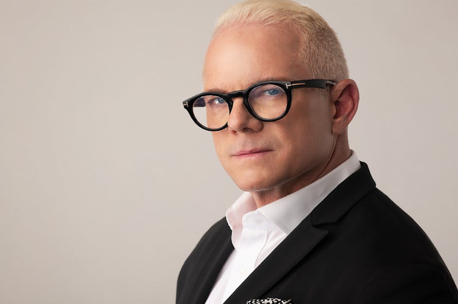 Elegant headshot of a blonde adult man wearing eyeglasses and a suit, perfect for corporate or fashion use